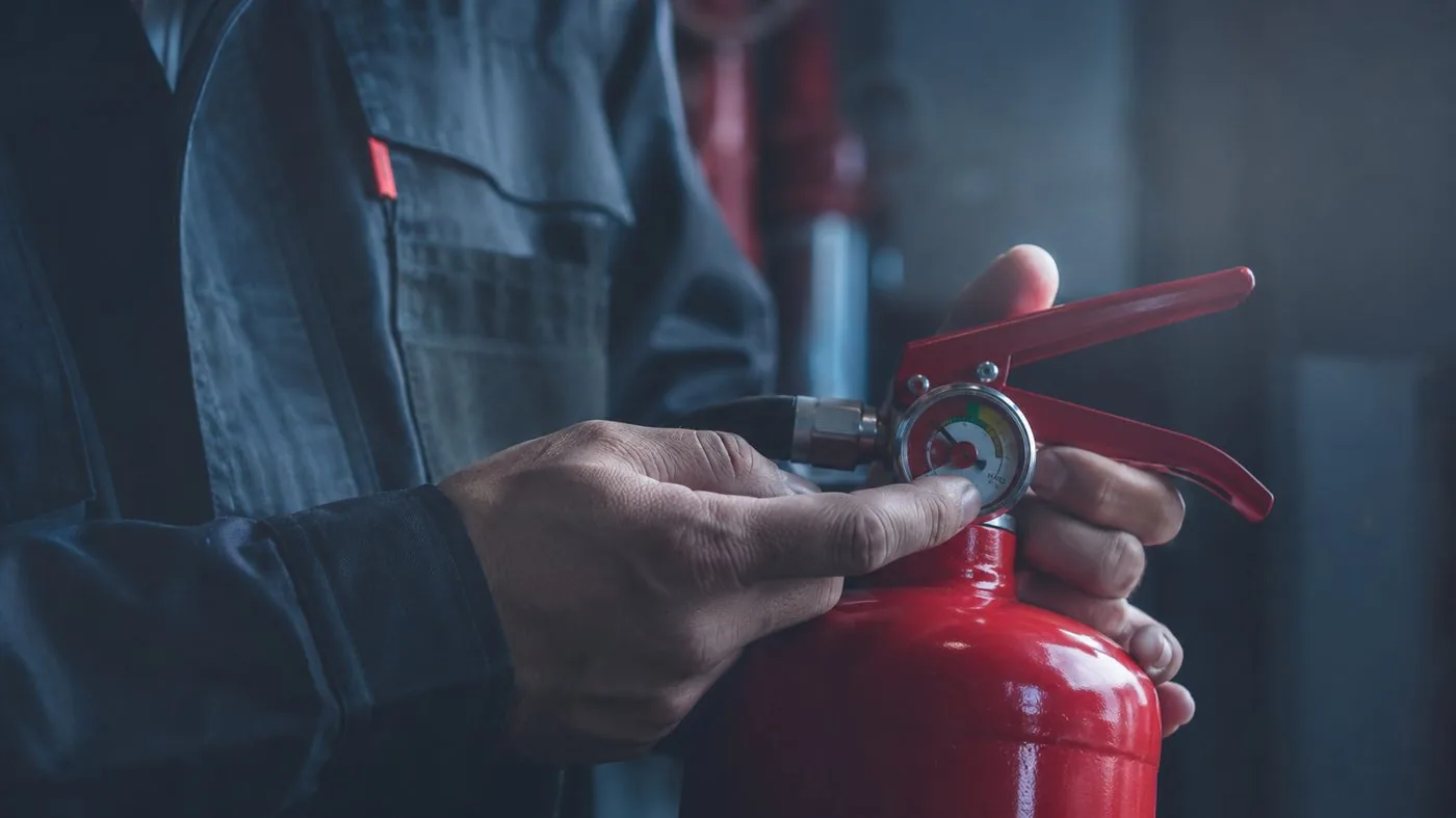 Técnico a verificar o manómetro de pressão de um extintor